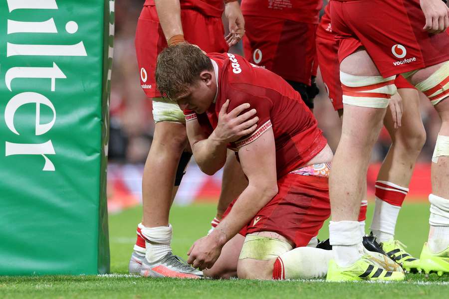Jac Morgan looks dejected as he holds his shoulder after picking up an injury whilst scoring Wales' third try