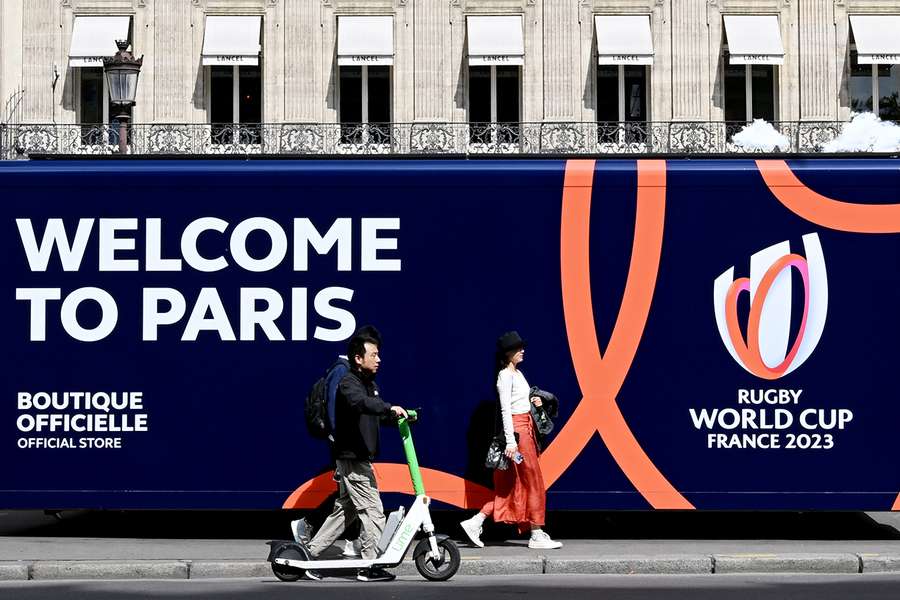 Pessoas passam por uma loja de merchandising com uma licença oficial do Campeonato do Mundo de Rugby 2023 no centro de Paris