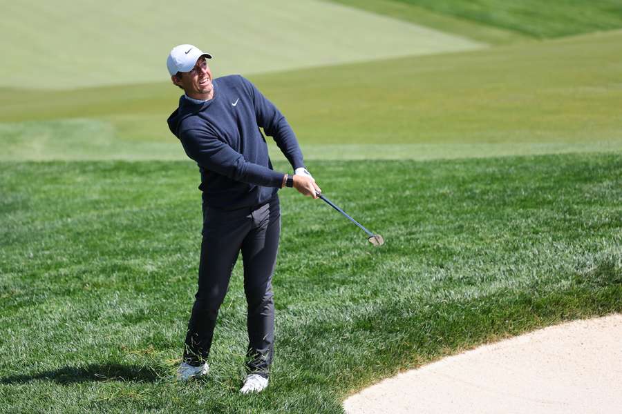 Rory McIlroy of Northern Ireland chips on the 14th green