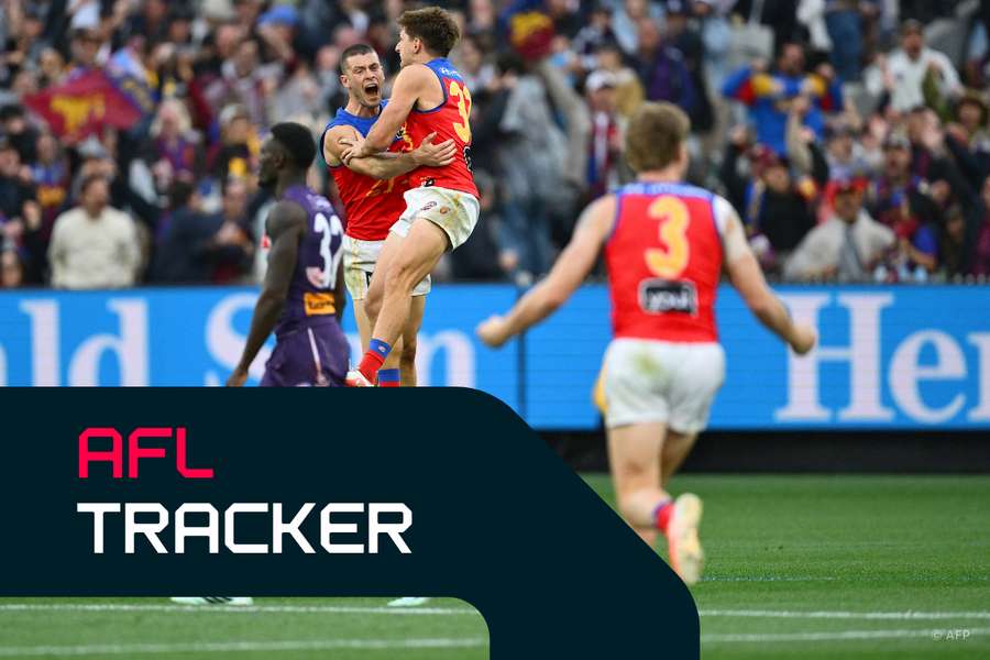 Brisbane players celebrate the goal that sealed their third consecutive Premiership.