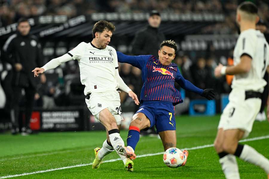 Joe Scally, left, and Leipzig's Antonio Nusa tussle for the ball