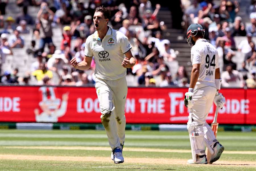 Australian bowler Pat Cummins (L) celebrates dismissing Pakistan batsman Shan Masood (R)
