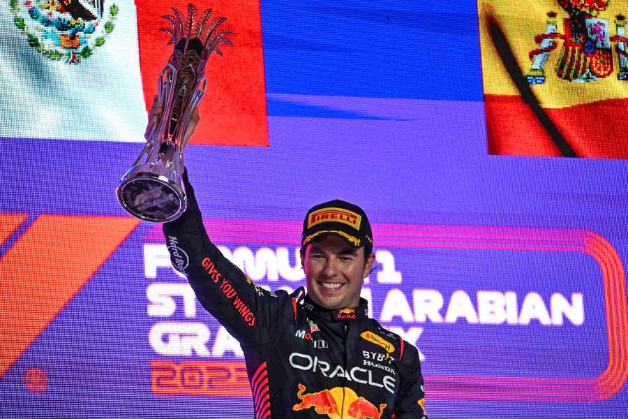 El piloto mexicano de Red Bull Racing, Sergio Pérez, celebra con el trofeo en el podio. 