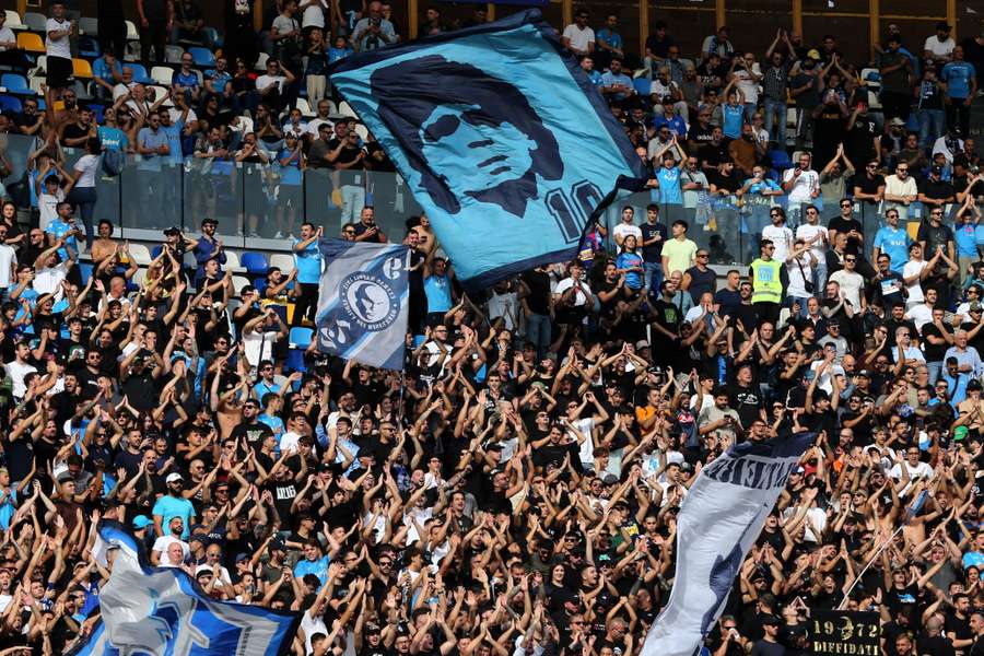 Afición del Nápoles con una bandera con la cara de Diego Armando Maradona