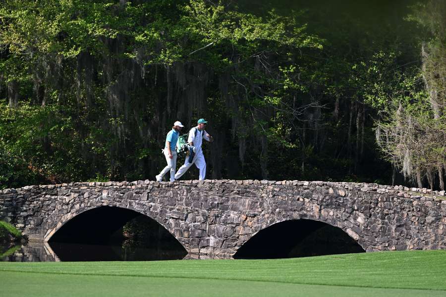 Tommy Fleetwood and caddie Ian Finnis cross the Nelson Bridge on the 13th hole