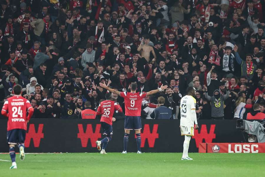 Olivier Giroud celebrates in front of Lille fans