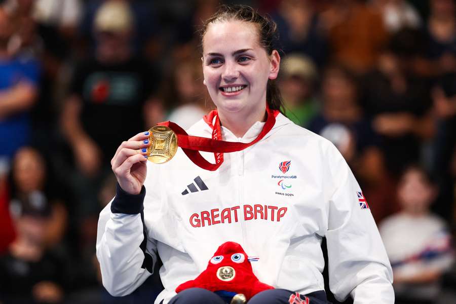 Tully Kearney celebrates on the podium after winning Paralympic gold for Britain in the women's 200m S5