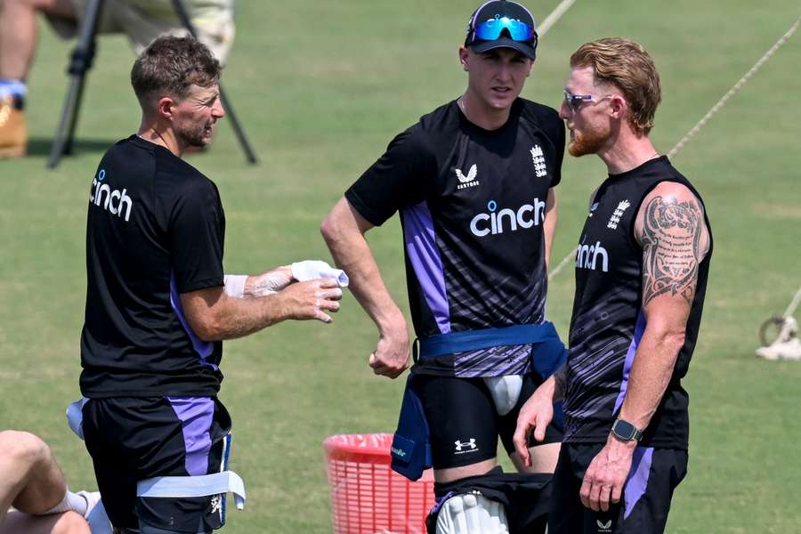 England's Ben Stokes (R) speaks with Joe Root (L) in trainnig