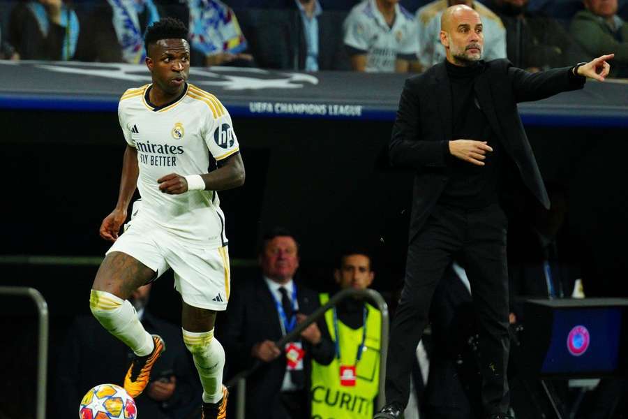 Guardiola e Vinicius Junior durante confronto entre Real e City na Champions