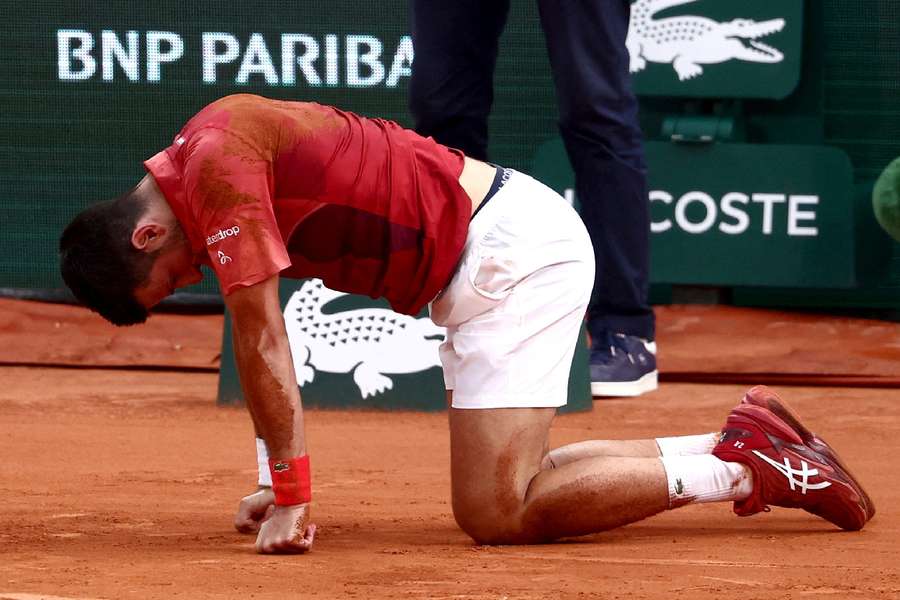 Novak Djokovic reacts after falling during his fourth-round match against Francisco Cerundolo
