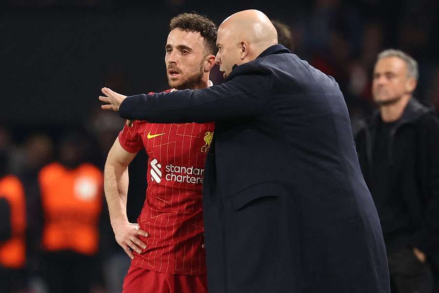 Liverpool's Dutch coach Arne Slot (C) gives instructions to Liverpool's Portuguese midfielder #20 Diogo Jota