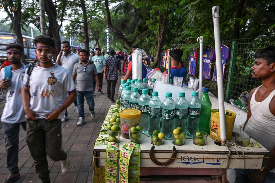 Fans walk by a refreshments stall in India during the heatwave