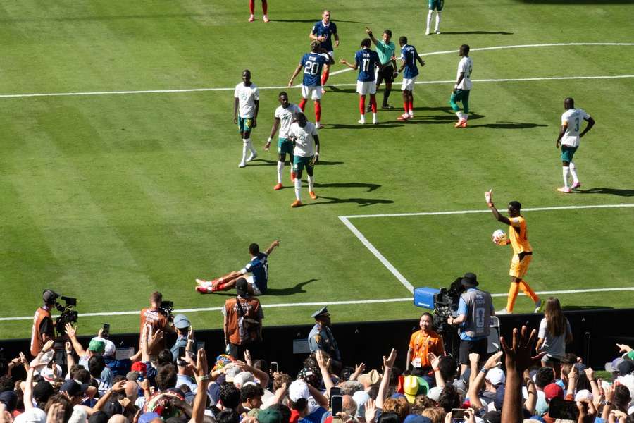France's Kylian Mbappe (seated) calls for a foul against Senegal France's Kylian Mbappe (seated) calls for a foul against Senegal