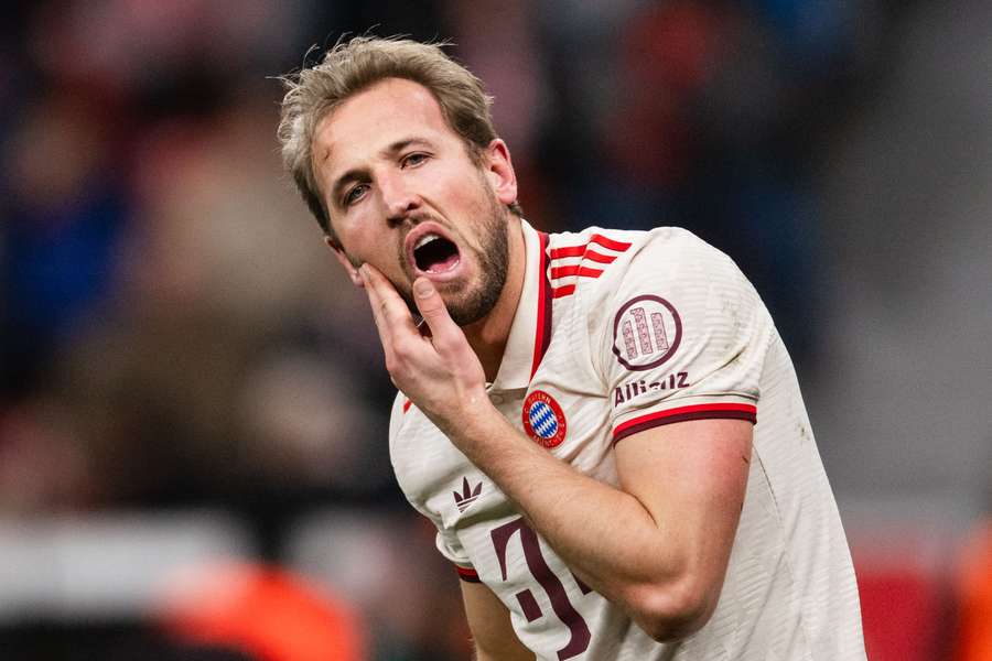 Harry Kane grabs his cheek after a collision