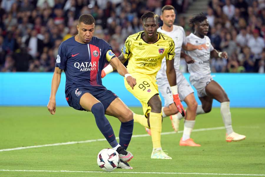 Paris Saint-Germain's French forward Kylian Mbappe (L) controls the ball next to Clermont-Ferrand's French goalkeeper Mory Diaw