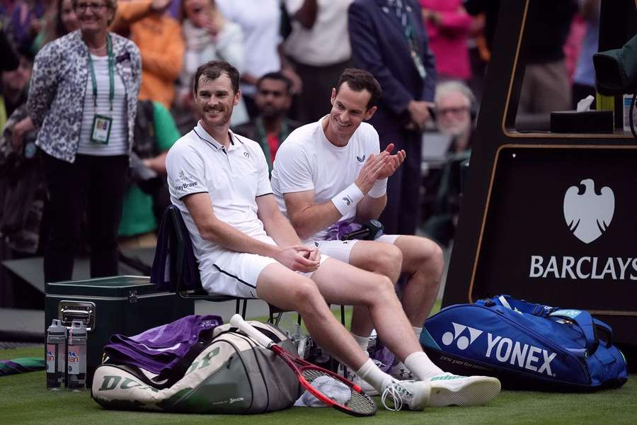 Jamie Murray sits next to his brother Andy during their doubles match on day four of the 2024 Wimbledon Championships