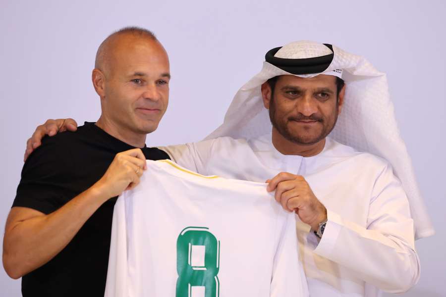 Spanish midfielder Andres Iniesta poses with his new jersey alongside Emirates Club Chairman Youssef Abdullah al-Batran