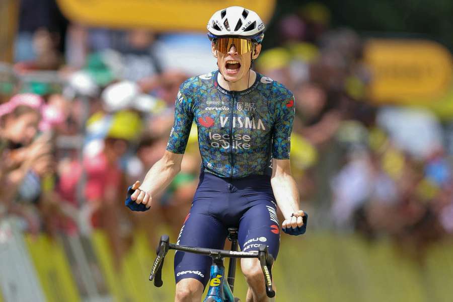 Jonas Vingegaard celebrates after crossing the line to win stage 11