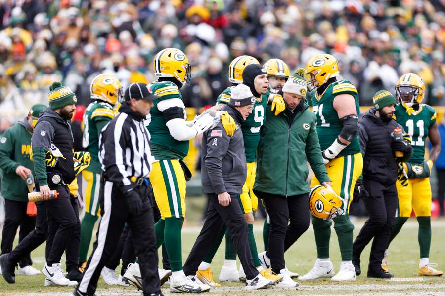 Green Bay Packers wide receiver Christian Watson walking off of the fielder after tearing his ACL
