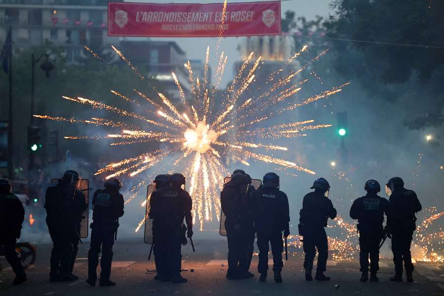 Vista geral da polícia nas ruas enquanto é lançado um fogo de artifício