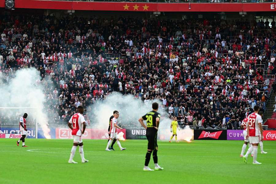 Kibice Ajaxu rzucają fajerwerki na boisko podczas meczu holenderskiej Eredivisie pomiędzy Ajaxem i Feyenoordem. 