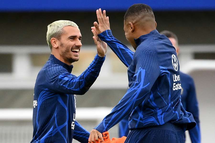 Antoine Griezmann y Kylian Mbappé chocan la mano durante un entrenamiento con Francia.