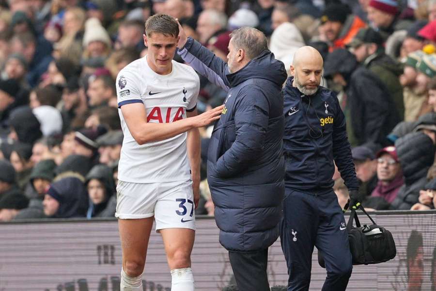 Micky van de Ven wordt getroost door Ange Postecoglou na zijn blessure