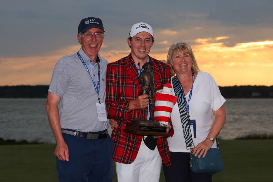 Matt Fitzpatrick (C) of England celebrates with the trophy in the Heritage Plaid tartan jacket alongside father Russell Fitzpatrick (L) and mother Susan Fitzpatrick (R)