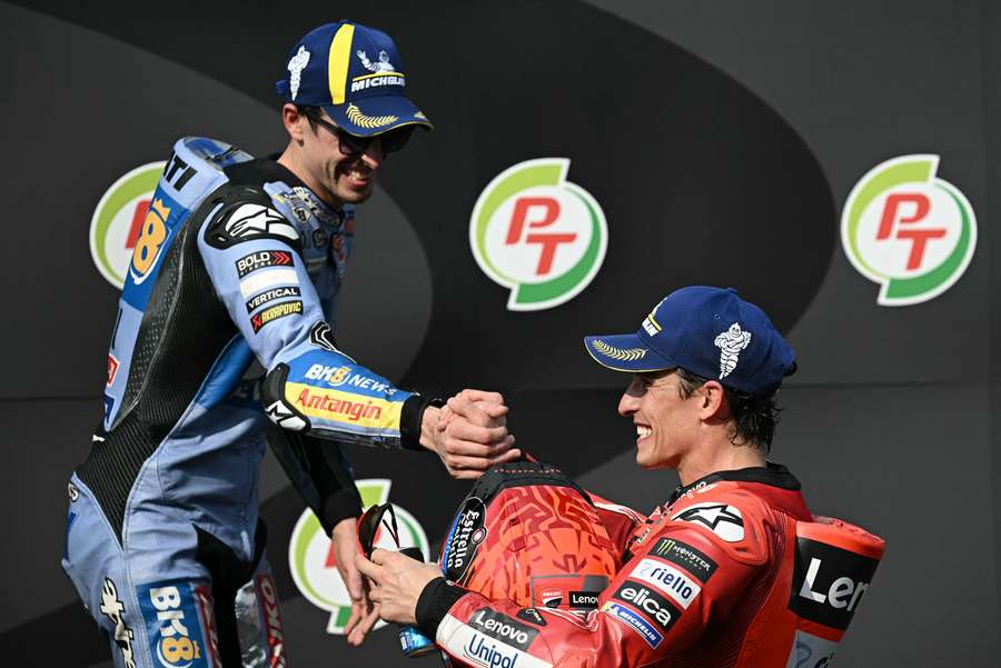 Ducati rider Marc Marquez (R) greets second-placed Gresini Racing rider Alex Marquez (L) on the podium after winning the MotoGP Thailand Grand Prix