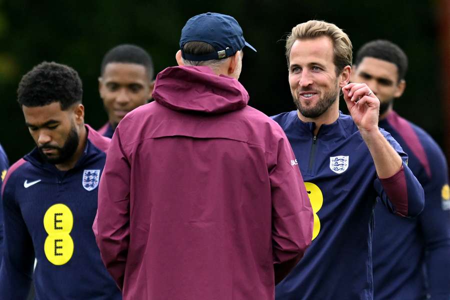 Harry Kane sonríe mientras habla con el técnico alemán de Inglaterra, Thomas Tuchel, durante un entrenamiento