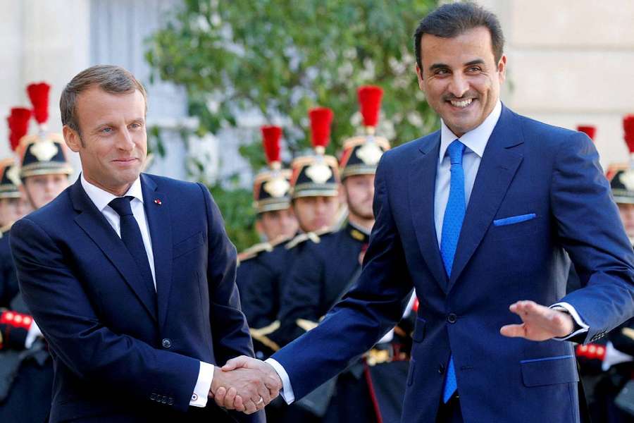 French President Emmanuel Macron shakes hands with Qatar's Emir Sheikh Tamim bin Hamad al-Thani in Paris 