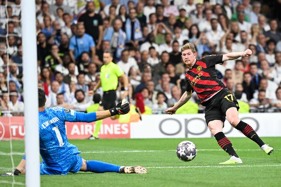 Manchester City midfielder Kevin De Bruyne challenges Real Madrid goalkeeper Thibaut Courtois (L)