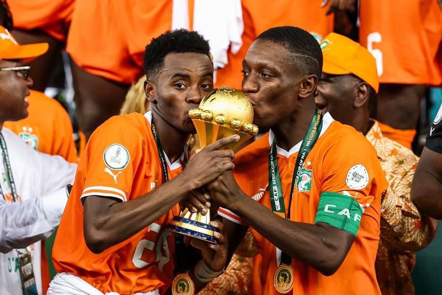 Ivory Coast's forward Max Gradel (right) and winger Simon Adingra kiss the Africa Cup of Nations trophy Ivory Coast's forward Max Gradel (right) and winger Simon Adingra kiss the Africa Cup of Nations trophy