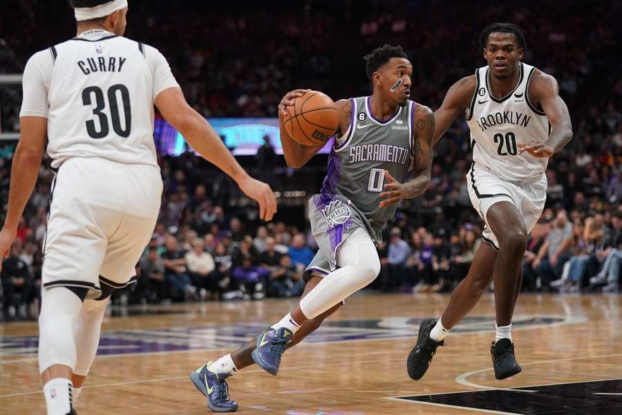 Malik Monk v drese Sacramenta prechádza cez obrancov Nets.