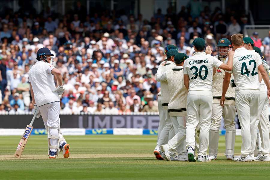 England's Jonny Bairstow (L) reacts as Australia celebrate his wicket following a review on day five of the second Ashes Test