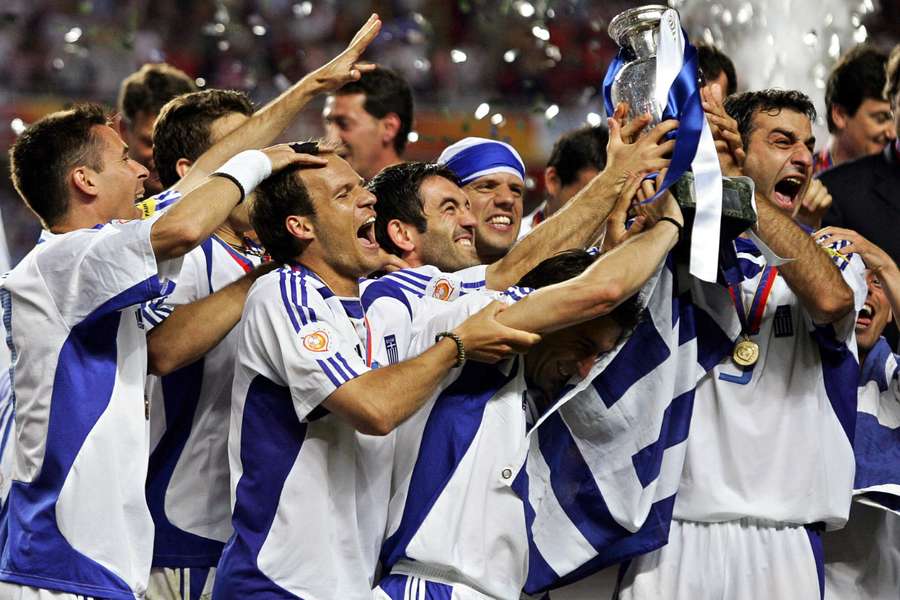 Greek defender Traianos Dellas (R) holds the Euro trophy in 2004