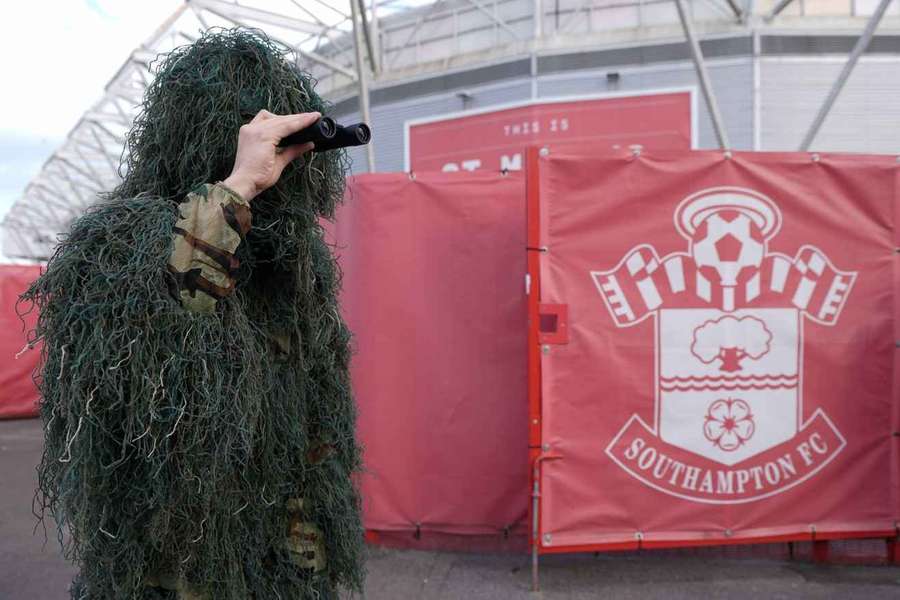 A Southampton fan stands outside St. Mary's Stadium dressed as a disguised spy