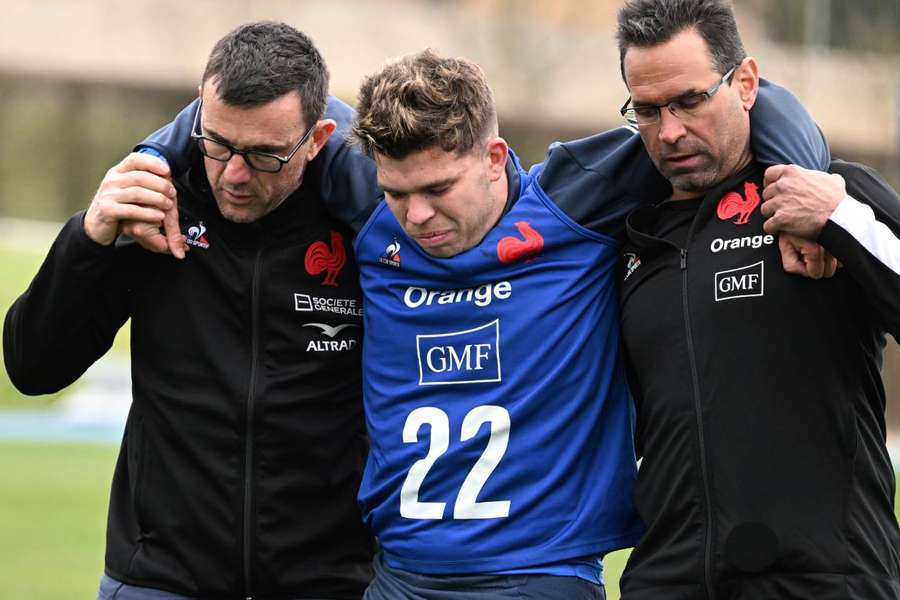 France's Matthieu Jalibert leaves the field after being injured