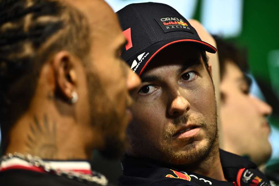 Sergio Perez listens to Mercedes' British driver Lewis Hamilton