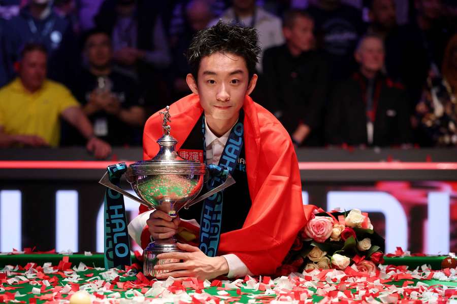 China's Wu Yize poses with the trophy after winning his final match against England's Shaun Murphy