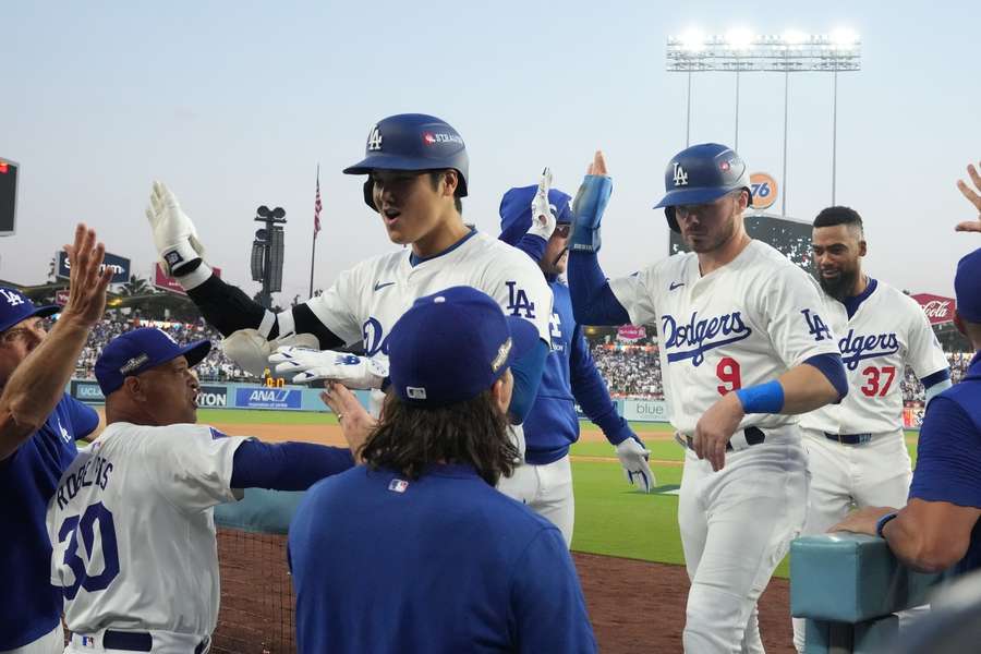 Los Angeles Dodgers' Shohei Ohtani (L), Los Angeles Dodgers' Gavin Lux (C), and Los Angeles Dodgers' Teoscar Hernandez celebrate with teammates