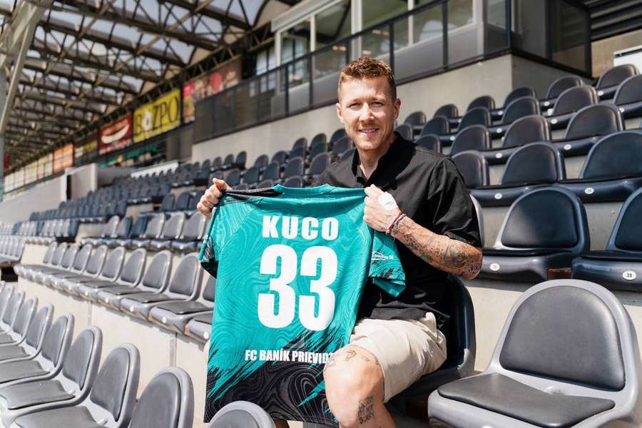 Kucka pózuje s novým dresom na tribúne prievidzského štadióna.