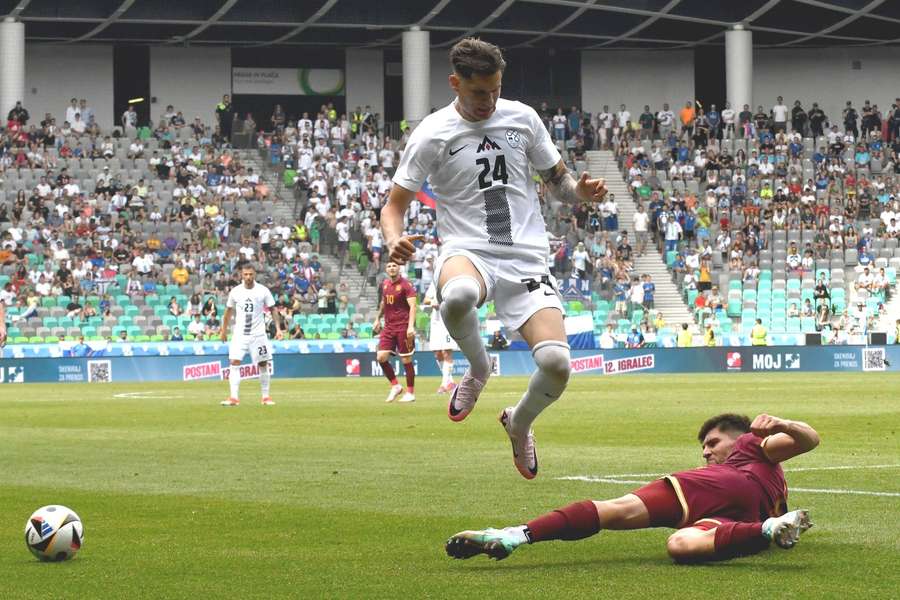 Nino Zugelj van Slovenië (L) ontwijkt een tackle