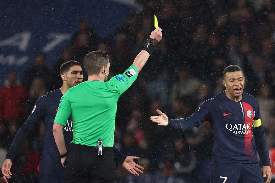 Mbappé recibe una amarilla durante un partido del PSG.