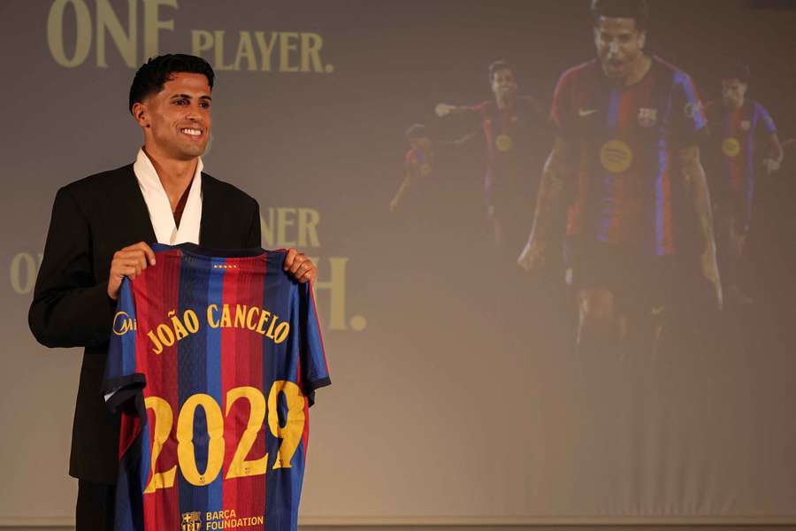 Cancelo poses with a Barcelona jersey during his official presentation Cancelo poses with a Barcelona jersey during his official presentation