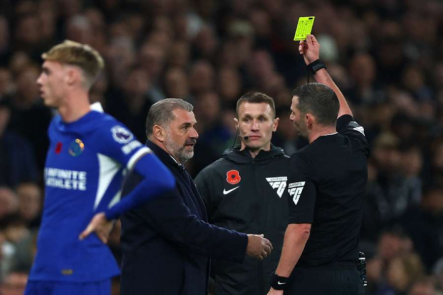  Tottenham Hotspur manager Ange Postecoglou is shown a yellow card by referee Michael Oliver against Chelsea
