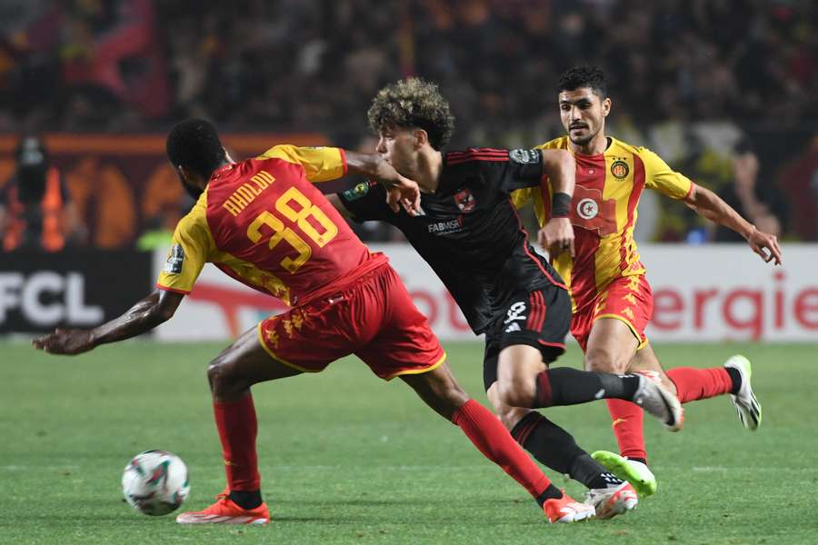 Al Ahly's Egyptian midfielder Emam Ashour runs past Esperance's Togolese midfielder Roger Aholou