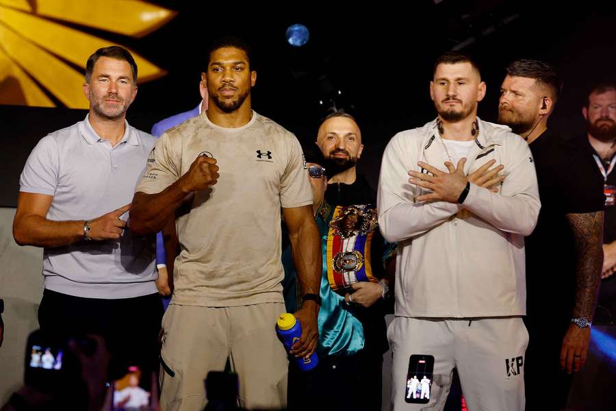 Anthony Joshua and Kristian Prenga pose during the press conference as promoter Eddie Hearn looks on Anthony Joshua and Kristian Prenga pose during the press conference as promoter Eddie Hearn looks on