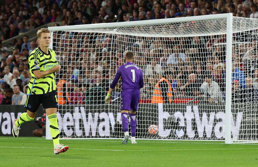 Arsenal's Norwegian midfielder #08 Martin Odegaard (L) celebrates scoring his team's first goal