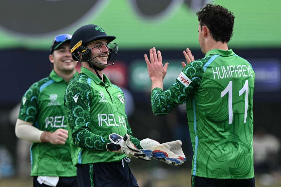 Ireland's Matthew Humphreys (R) celebrates with his captain Lorcan Tucker (C) after taking the wicket of Oman's Shakeel Ahmed 